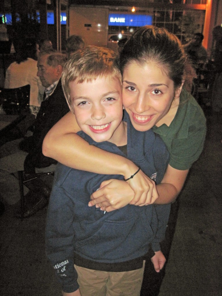 A small boy is hugged by a teenage waitress at the Smile Cafe in Athens.