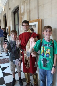 The author's children with a costumed actor doing the welcome greeting of the Roman Legion