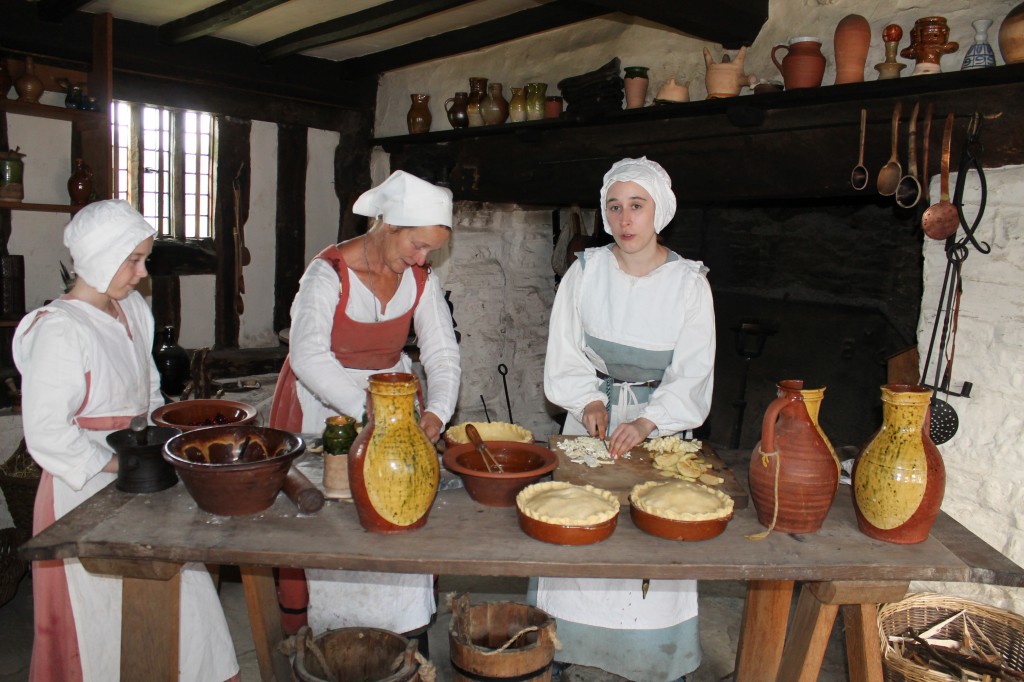 Costumed actors prepare Elizabethan-era baked goods.