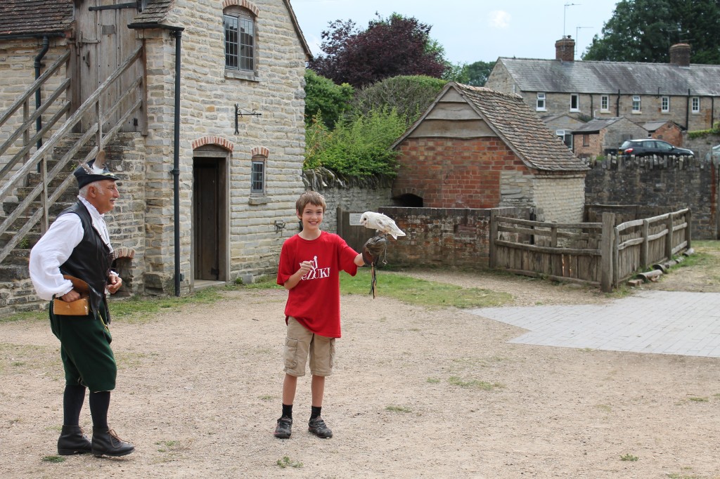 The author's son stands next to a costumed Falcon Master. The child is holding a white owl and grinning happily.