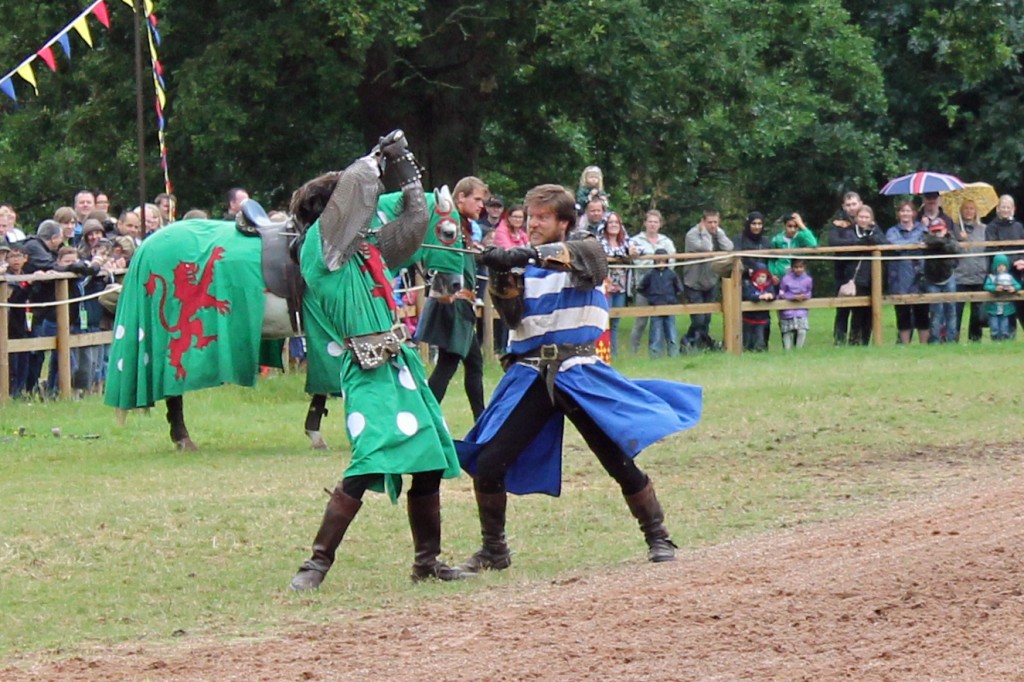 Actors in medieval costume stage a swordfight