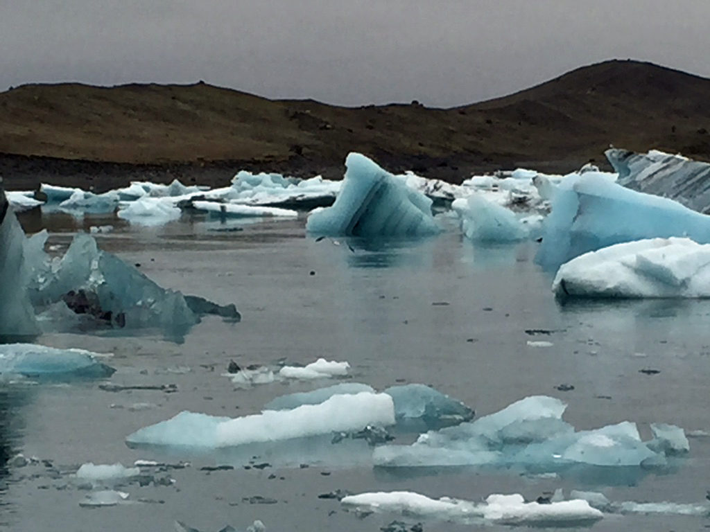 bright blue icebergs bob in a lake 