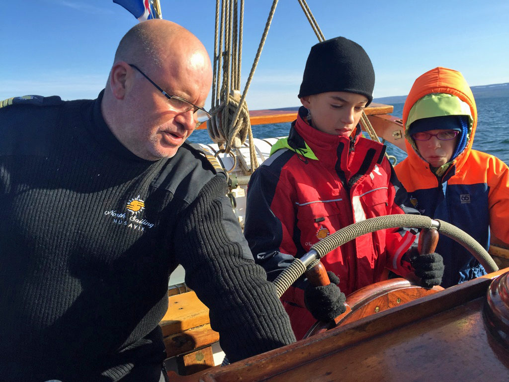 The author's children have a turn steering the boat, with the captain offering instruction