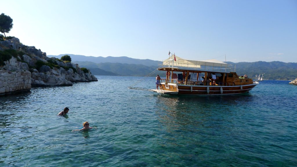 The author's family swims in a sheltered bay with a picturesque boat nearby