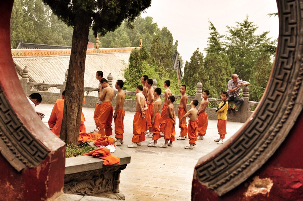 A group of boys from young to teenager wearing orange trousers prepares for a lesson