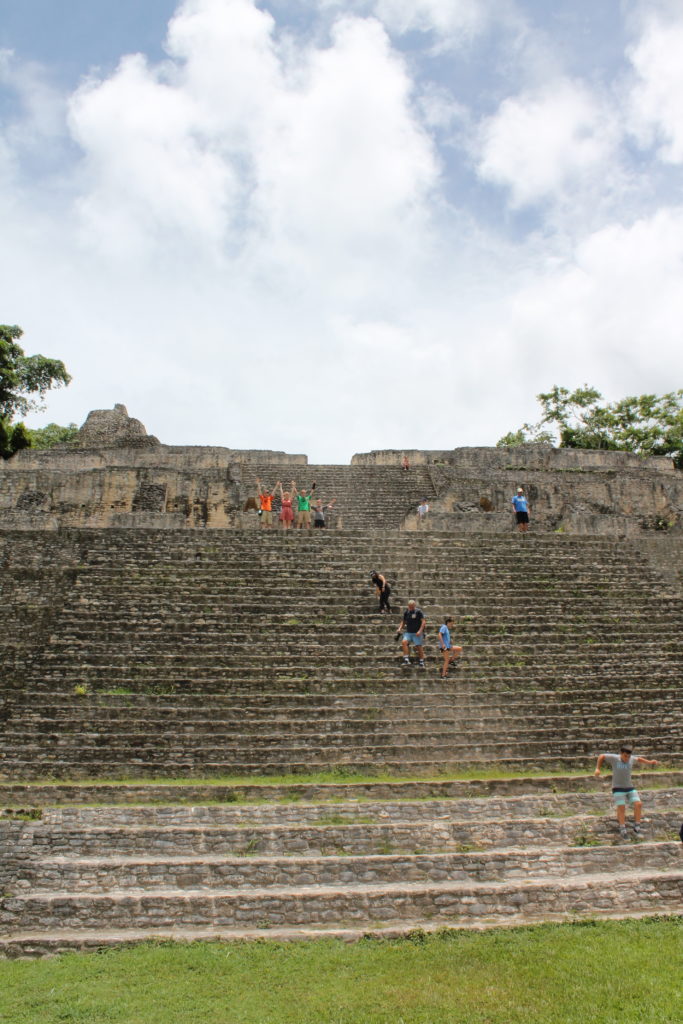 The author and her children raise their arms in victory halfway up a temple ruin
