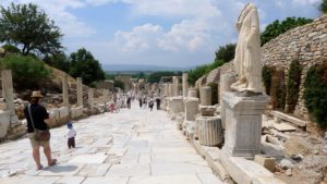 A paved ancient walk lines with statues