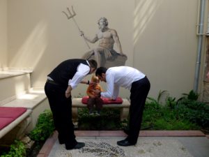 The author's son on a bench being fawned over by hotel employees